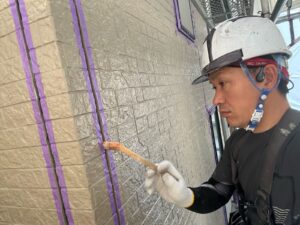 右利きの職人がプライマーを塗っている